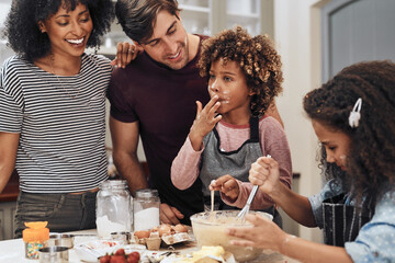 I can tell its going to be delicious. Cropped shot of a young couple baking at home with their two children.