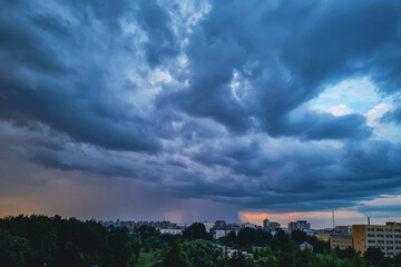Obraz premium Storm clouds close up. Dramatic sky over city. Thunderstorm weather. Rain pours from cumulus clouds.