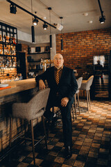 a man in a suit sits at the bar in a restaurant