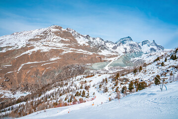 Fototapeta premium Majestic snow covered mountain range against blue sky in alps