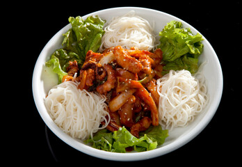 Stir-fried octopus side dish and noodles on a black background