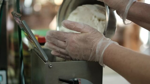 Chef cooks Italian spaghetti using a pasta machine.He pours flour and semola into a pasta machine