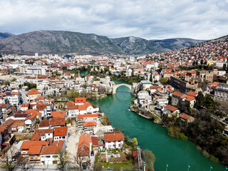 Fototapeta na wymiar Old Bridge and Neretva river in Mostar, Bosnia and Herzegovina. Panoramic view of Mostar in spring, aerial drone view. 