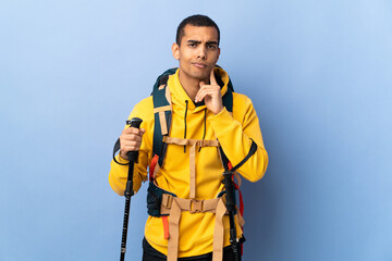 African American man with backpack and trekking poles over isolated background and thinking