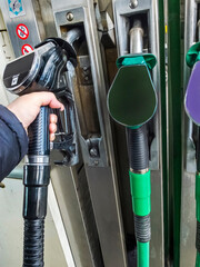 Mans arm holding a diesel fuel pump trigger nozzle, at a filling station,England,United Kingdom. - obrazy, fototapety, plakaty