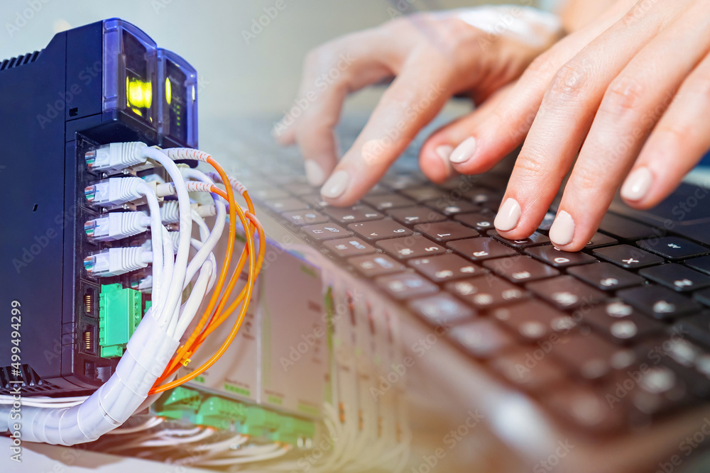 Poster computer technology. a person is working on a computer against the background of network equipment. 