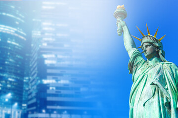 Fototapeta premium Statue of Liberty on a blurry background of skyscrapers. Statue of Liberty on the background of the World Trade Center. Sights of New York. Collage with a blue background. Place for text.