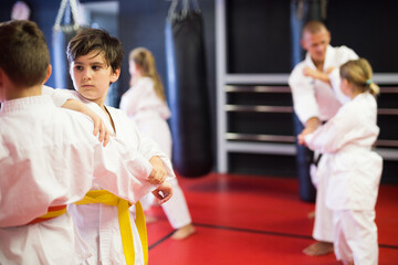 Young boys training in pair to use karate technique during class