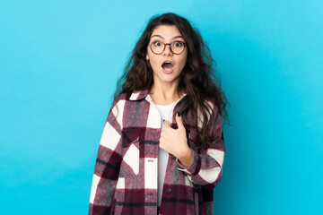 Teenager Russian girl isolated on blue background with surprise facial expression
