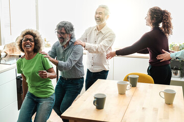 Happy multiracial people having fun dancing in the kitchen at home - Focus on african girl face