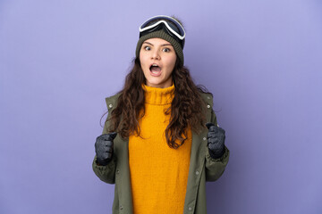 Teenager Russian girl with snowboarding glasses isolated on purple background celebrating a victory in winner position