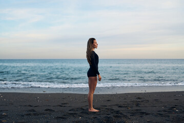 Fototapeta na wymiar woman doing a yoga practice at the beach while a beautiful sunset