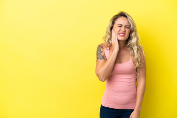 Young Brazilian woman isolated on yellow background with toothache