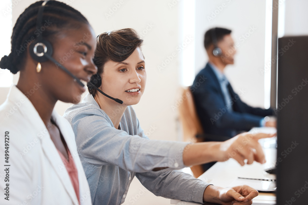 Poster Sharing tips on easier ways to solve inquiries. Shot of two call centre agents working together on a computer in an office.