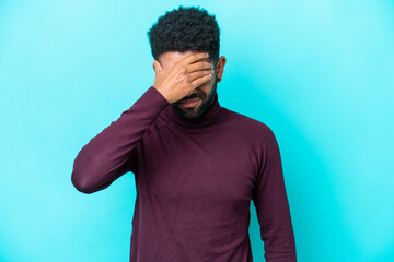 Young Brazilian man isolated on blue background with headache