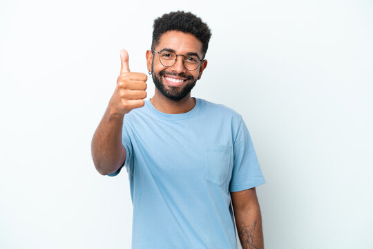 Young Brazilian man isolated on white background with thumbs up because something good has happened