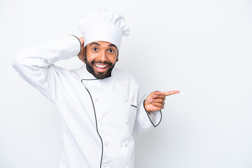 Young Brazilian chef man isolated on white background surprised and pointing finger to the side