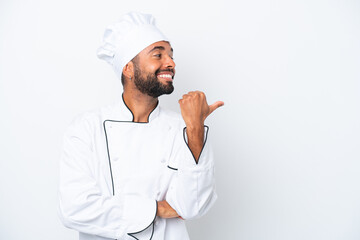 Young Brazilian chef man isolated on white background pointing to the side to present a product