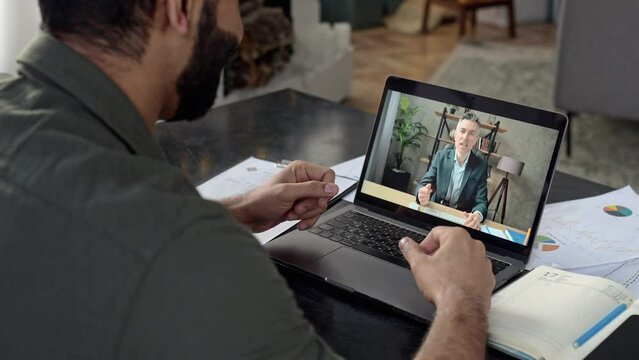 Online business briefing. An Indian successful man conducts business negotiations with his influential caucasian mature colleague, financial mentor, discussing financial strategy, risks, using laptop
