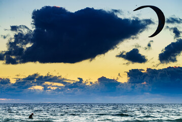Kite surfer riding waves. Kiteboarding sport.