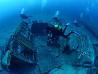   ship wreck underwater deep sea bottom metal on ocean floor scuba divers to explore