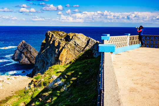 Tourist with camera on Asturias coast, Spain
