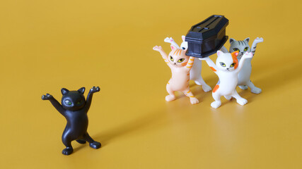 Toy funeral procession of five funny dancing kittens carrying a black coffin. Call for...