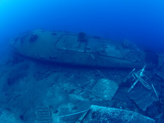   ship wreck underwater deep sea bottom metal on ocean floor scuba divers to explore