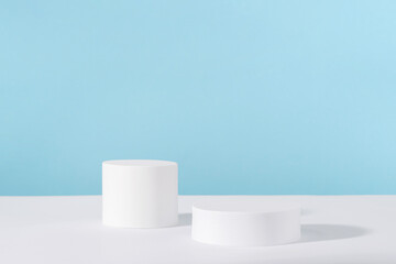 Podium pedestal for cosmetic product packaging on blue background. Showcase for jewellery presentation, white platform for perfume advertising, cosmetics stand background, branding scene mockup