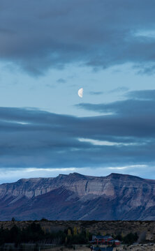 satélite natural, luna gibosa creciente en cielo de atardecer azul, sobre cerro 