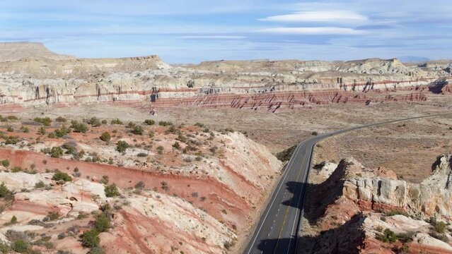Aerial drone view over a road between dry, bare mountains in sunny Arizona, USA