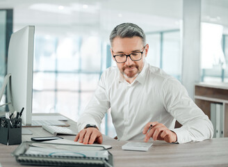 Theres still some room for reinvesting. Shot of a mature businessman sitting alone in his office and calculating his finances.