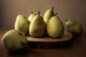 Rustic still life art of fresh ripe pears on wooden background.