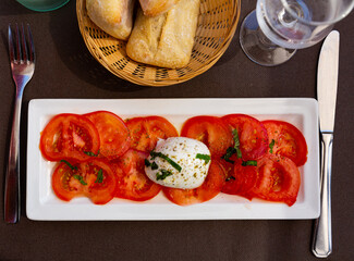 Plate with slices of tomatoes and mozzarella cheese, dish of Italian cuisine