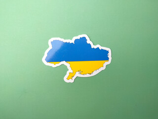 Ukraine flag stickers on a green background.