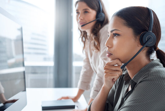 I Think We Need To Look Into This. Shot Of Two Businesswoman Working Together In A Call Centre Office.