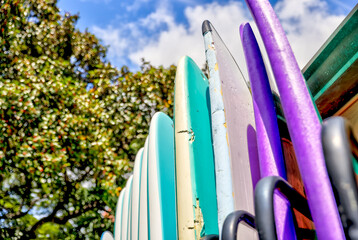 Surfboards lined up in a rack along the streets of Waikiki
