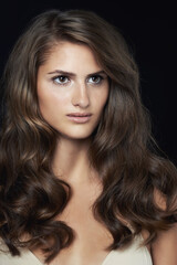 Fototapeta premium Dark beauty. A gorgeous brunette posing in front of a black background.