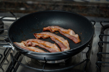 Slices of bacon have been fried for breakfast.