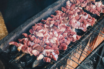 Raw Goat Satay Klathak making process on a charcoal grill.