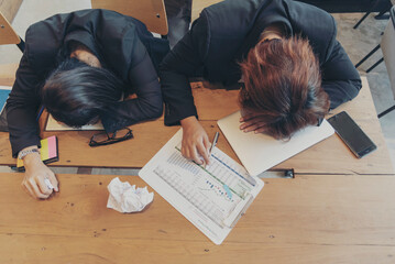 Top view two Asian businesswoman overworked at office desk feel stressful anxiety with serious...