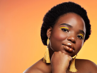 Dont let anyone dull your glow. Studio shot of a beautiful young woman posing against an orange...
