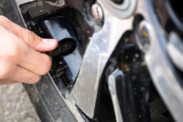 Man checking air pressure and filling air in the tires of car. Concept picture