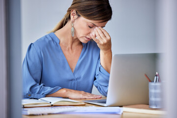 This day has been so stressfull. Shot of a businesswoman experiencing a headache at work.