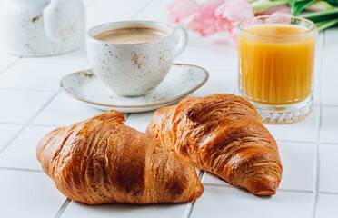 French Breakfast with Croissants, Orange Juice and Coffee with pink tulips