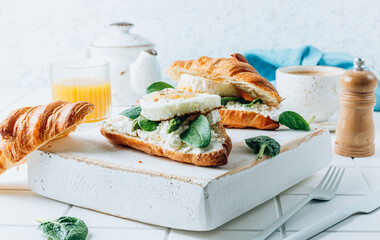 Delicious Breakfast with Croissant sandwiches with Fried Egg, spinach, and Coffee and Orange Juice on white background,