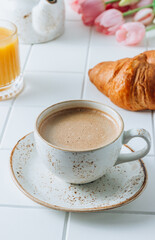 French Breakfast with Croissants, Orange Juice and Coffee with pink tulips
