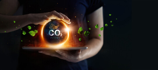 Man hold earth energy at night on tablet depicting the issue and reduce CO2 emissions carbon. Global warming and climate change. Energy saving, Sustainable development. Earth day. - obrazy, fototapety, plakaty