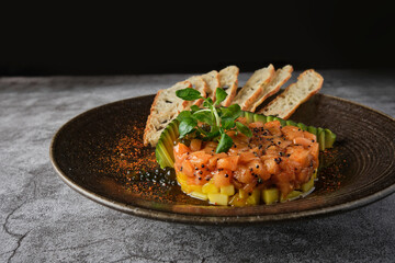 Gourmet fish tartar raw from tuna fillet with hashed avocado, selective focus