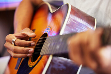 Fototapeta premium Hes hitting all the right notes. Cropped shot of an unrecognizable male musician playing his guitar at home.